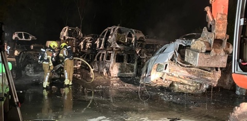 brandweer blust de stapel auto's een voor een af.