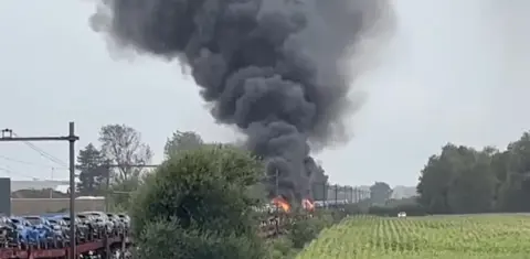 -Auto's in brand op een goederentrein. Fotograaf 112 vandaag