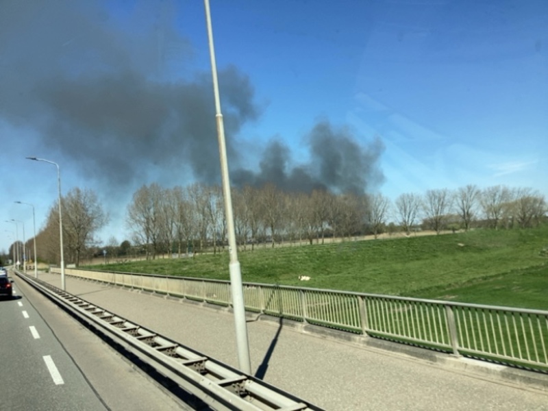 Zwarte rookwolk over de snelweg