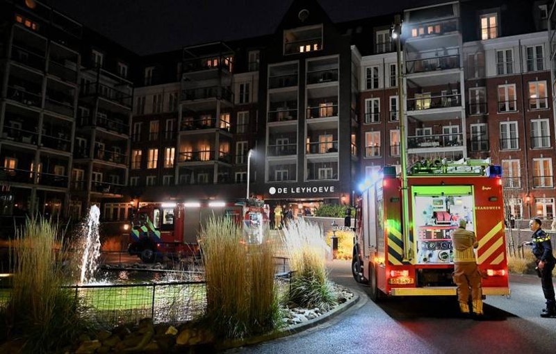 Groot gebouw met brandweerauto ter plaatse